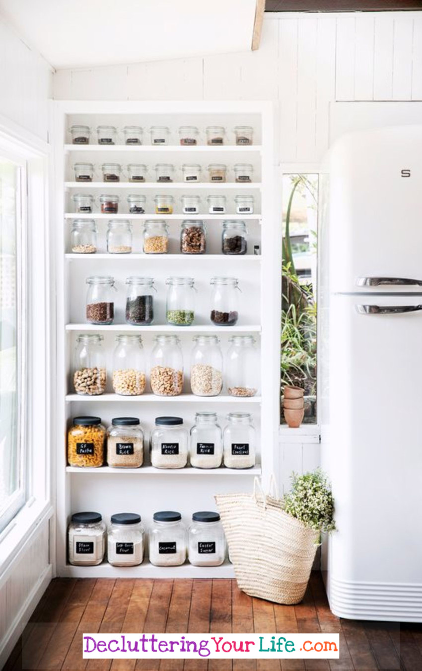 Declutter your kitchen!  This beautiful white kitchen uses this simple DIY shelves idea to organize and declutter in their kitchen.  LOVE all the different size canisters for displaying their pantry goods!